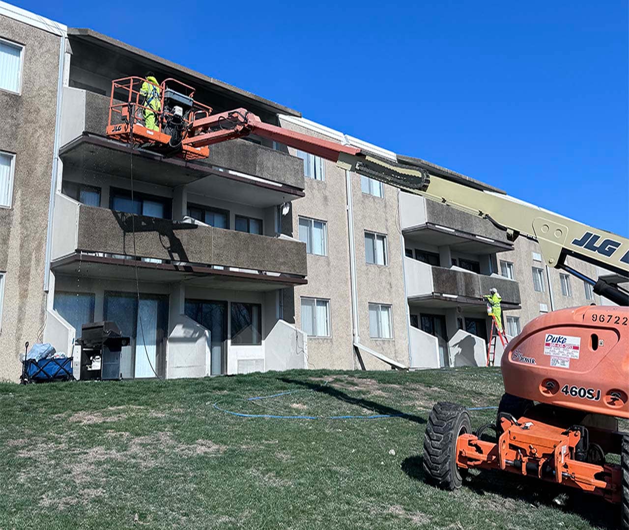Pro clean mobile wash team power washing apartment building.
