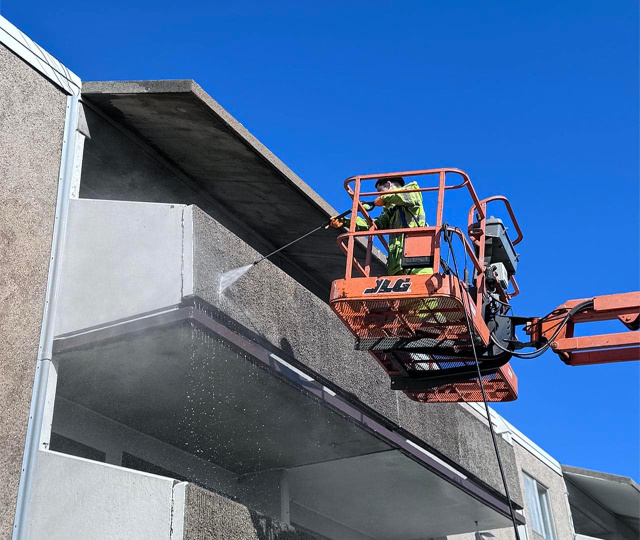 Pro clean mobile wash team power washing apartment building.