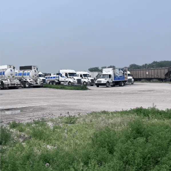 Reagent Pressure washing truck fleet at commercial property yard.